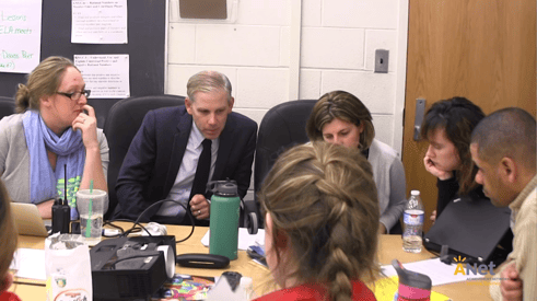 Photo of educational leaders collaborating around a big table